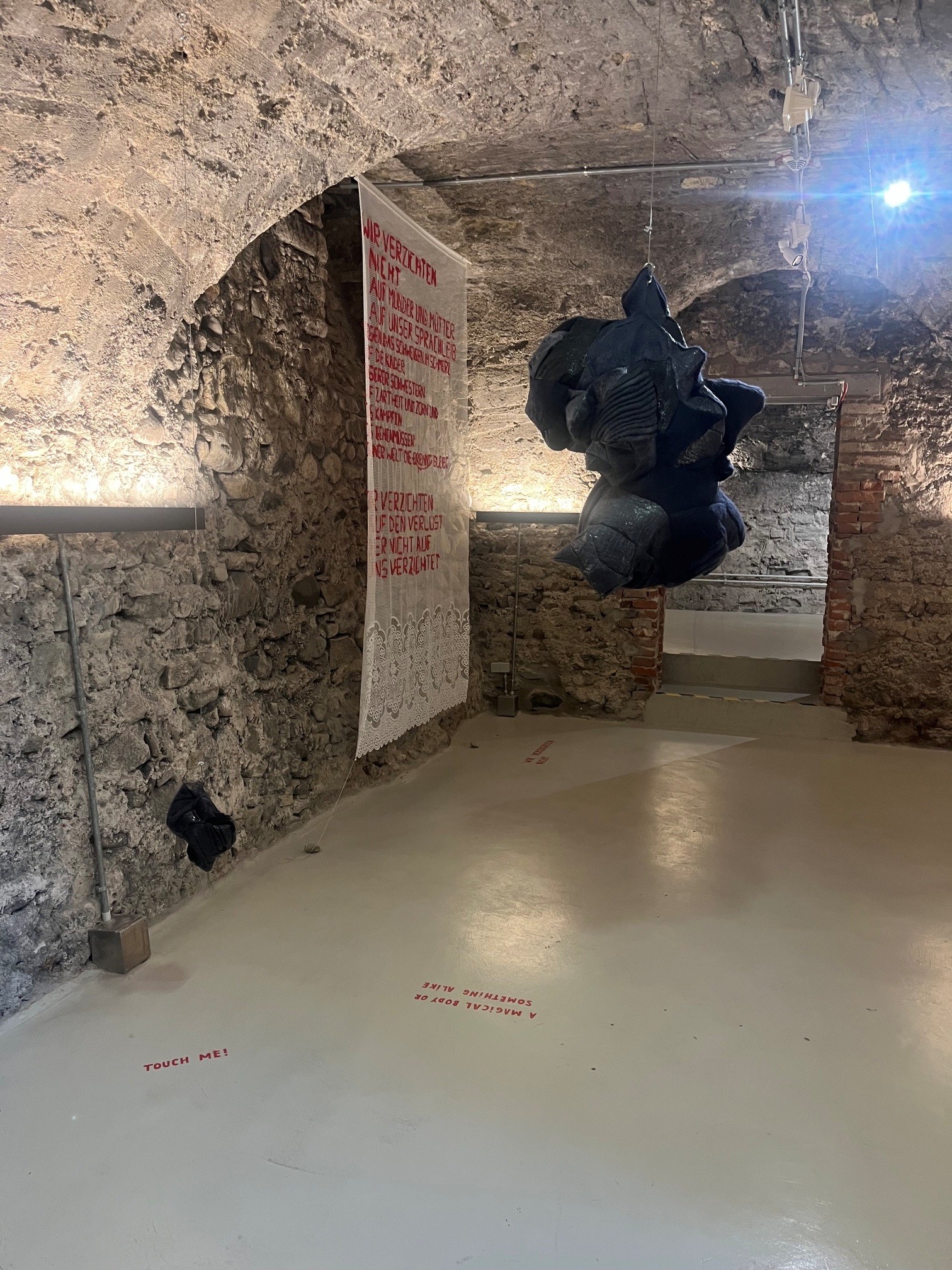 Ausstellungsansicht im Gewölbekeller mit hängender Skulptur unter dem Gewölbe